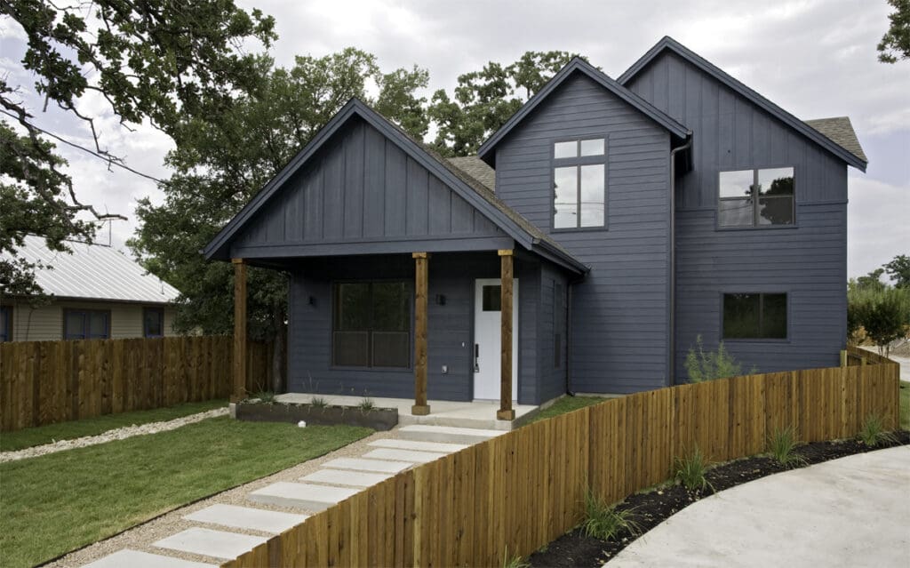 Modern gray house with wooden fence and walkway.