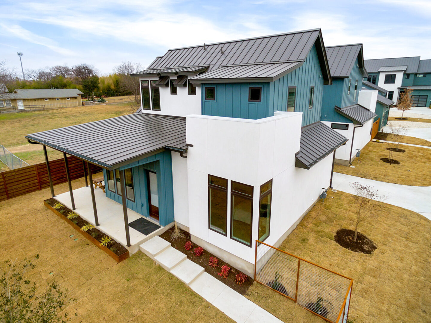 Aerial view of a modern home with blue siding.