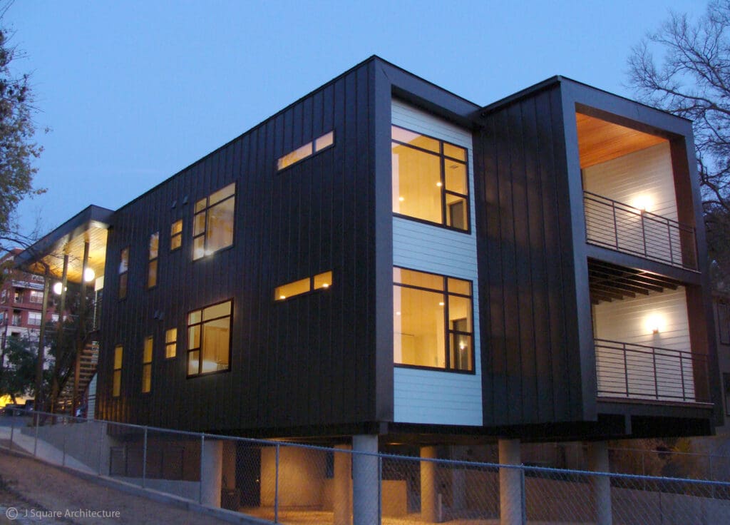 Modern house with large windows and a balcony.