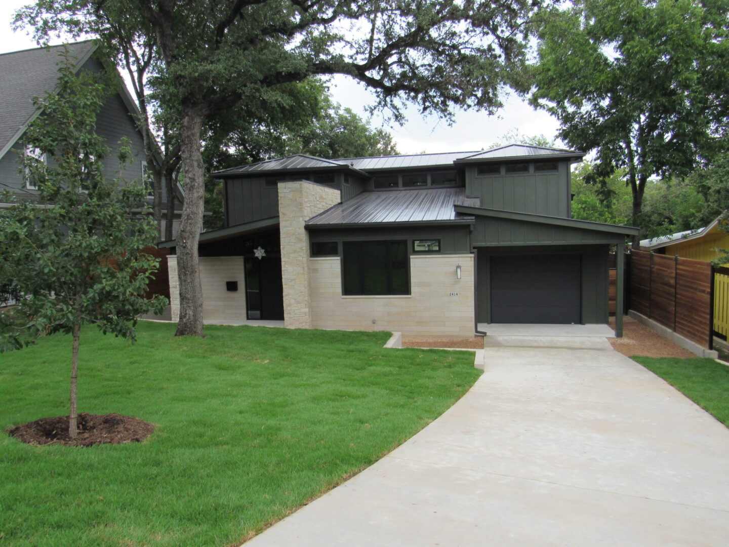 Modern house with a driveway and green lawn.