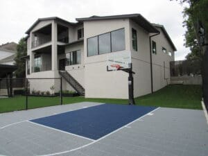 Basketball court outside modern house.