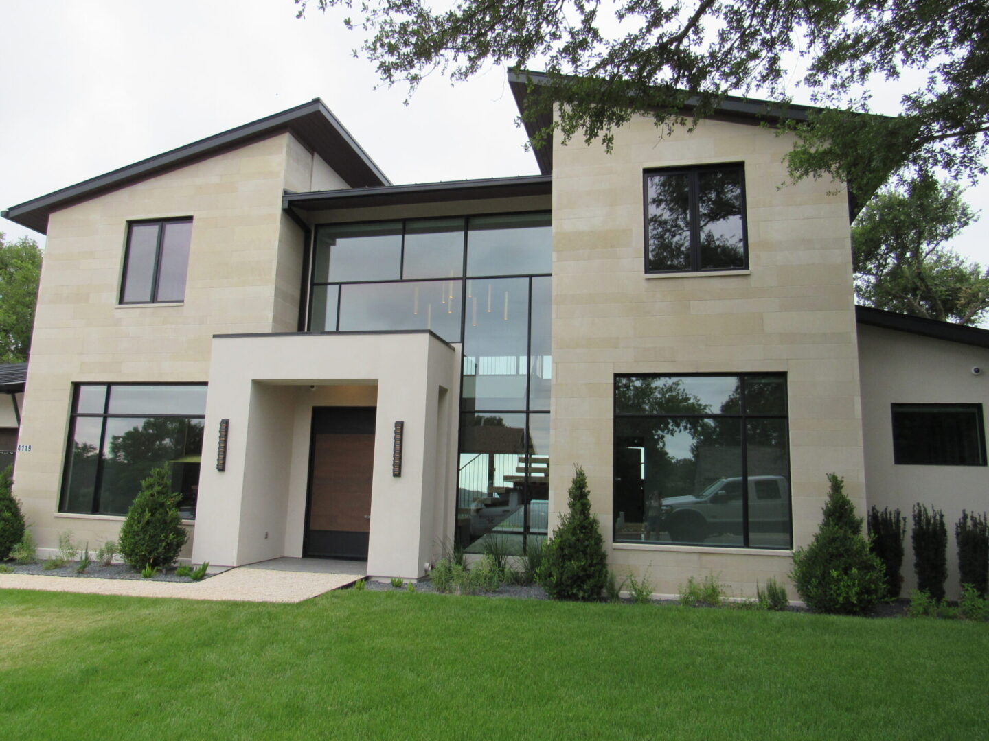 Modern house with large windows and landscaping.