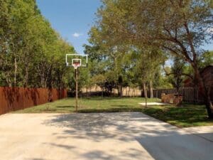 Basketball hoop in a grassy backyard.